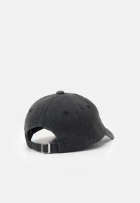 Svart stoff baseballcap med rund krone, justerbar stropp med metallkomponenter og teksturert overflate.