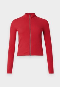 Rote, gerippte Langarmjacke mit hohem Kragen und silbernem Zwei-Wege-Reißverschluss vor schlichtem hellem Hintergrund.