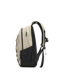 Zaino con corpo di un beige chiaro strutturato e base nera, dotato di numerizie cerniere e spallacci regolabili. Tasca laterale in tessuto nero.