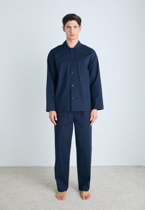Ensemble de pyjama bleu marine en tissu doux. Chemise à manches longues avec fermeture à boutons, pantalon assorti. Design simple, sans motifs ni accents.