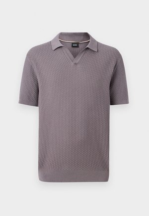 Πόλο πλεκτό σε μωβ απόχρωση με κοντά μανίκια και υφή βαφλάδας, ανοιχτό γιακά και ριμπ μανσέτες και τελείωμα, με μικρή μαύρη ετικέτα στο εσωτερικό του γιακά.