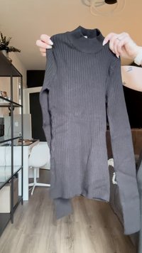 Svart ribbet turtleneck genser med lange ermer, laget av myk stoff, med en tettsittende design og litt avrundet hem.
