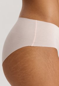 Intimo seamless rosa chiaro con una texture morbida, caratterizzato da un elastico morbido. Il materiale sembra elastico e aderente.