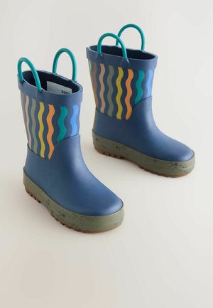 Bottes de pluie en caoutchouc bleues avec un motif ondulé en orange, vert et bleu. Elles disposent d'une semelle verte avec des éclats et de poignées bleues.