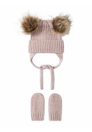 Bonnet de bébé tricoté rose avec deux pompons en fourrure et des moufles assorties, tous deux avec des détails côtelés et des cordons noués sous le bonnet.
