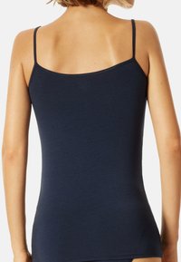 Navy blue tank top with thin straps, made from a soft, smooth material. The design features a fitted shape and a simple, classic silhouette.