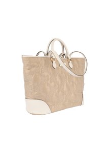 Beige quiltad toteväska med vita läderdetaljer och handtag. Har ett blommigt mönster och beslag i guldton. Rymlig design.