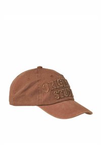 Brun bomuldsbaseballkasket med broderet "Original Studio" tekst, buet skygge, knap på toppen og ventilationsøje på siderne.