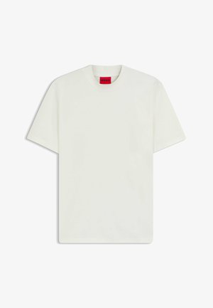 Valkoinen puuvillapaita, jossa on pyöreä kaula-aukko, lyhyet hihat ja punainen brändilappu kauluksessa. Minimalistinen muotoilu, ilman kuvioita tai korostuksia.