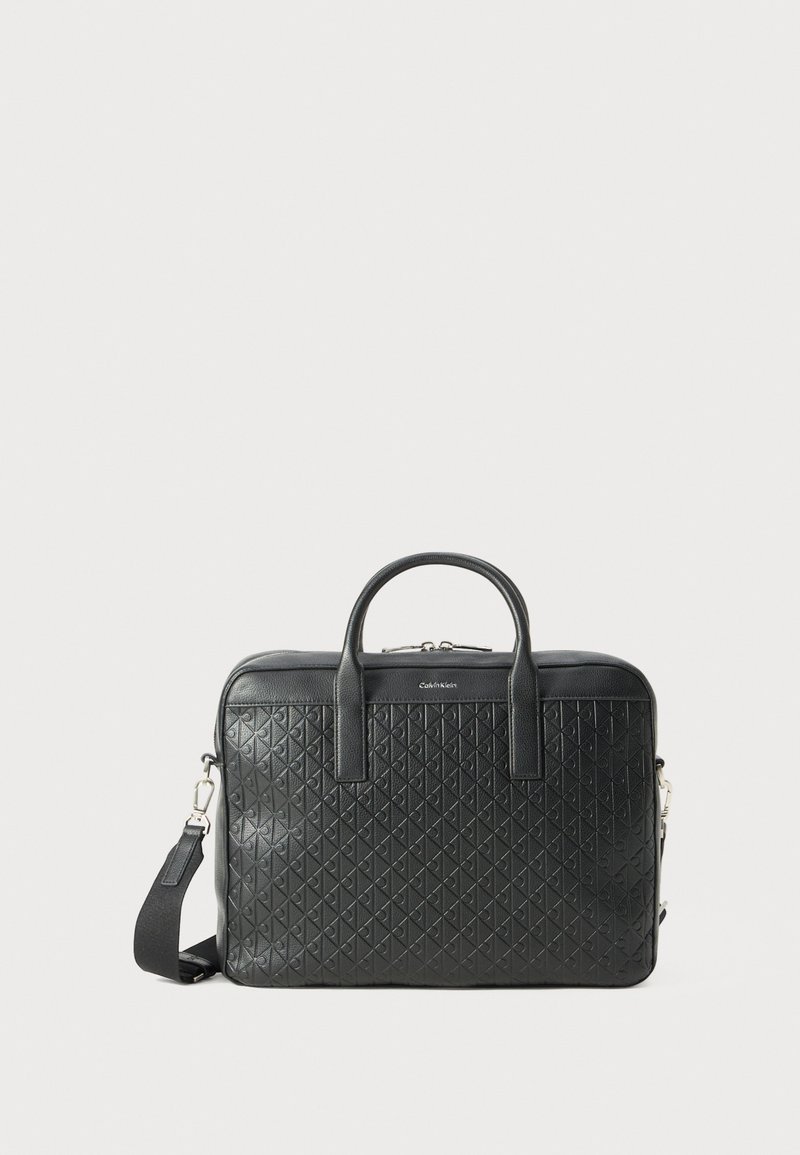 Bolso de cuero negro con un patrón de diamantes acolchado, dos asas y una correa de hombro desmontable. Presenta un diseño rectangular elegante.