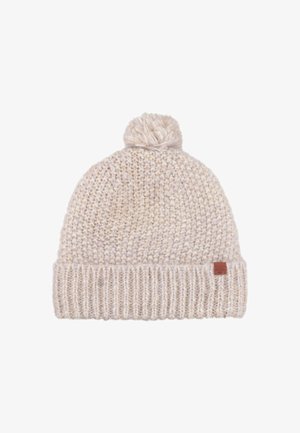 Knit beanie in light beige, featuring a fluffy pom-pom on top, ribbed cuff, and a small leather label on the side. Soft texture.