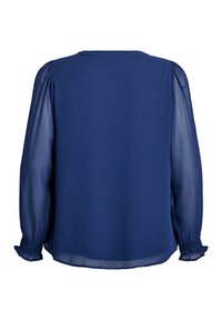 Blouse bleu marine avec un corps texturé uni, des manches bouffantes transparentes et des poignets froncés. Présente un simple col rond à l'arrière.