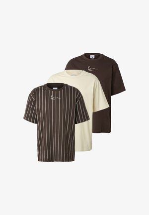 Drei kurzärmlige Rundhalsausschnitt-T-Shirts in Creme, sattem Dunkelbraun und Dunkelbraun mit weißen vertikalen Streifen, jeweils mit einem kleinen weißen Signaturdruck.