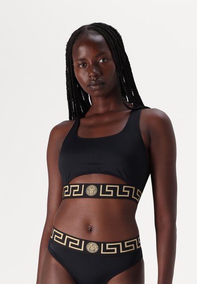 Μαύρο σετ μπικίνι με κομμένο τοπ με τετράγωνη λαιμόκοψη και ταιριαστό ψηλόμεσο σλιπ, και τα δύο τονισμένα με χ�ρυσή γραφική ζώνη.