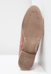 Zapato rosa de ante con una parte superior lisa, suela plana de goma y dibujo texturizado. Talla '37' marcada en la suela.