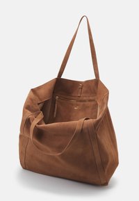 Brown suede tote bag with two long handles, spacious interior, and an external zipper pocket. Smooth texture and minimalist design.