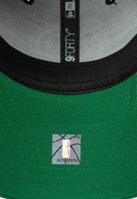 Cappello da baseball verde con visiera nera, tessuto texturizzato e fodera interna grigia. Presenta un'etichetta del logo NBA sul lato interno.
