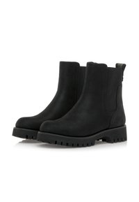 Par de botas de tobillo de ante negro con suelas gruesas y paneles laterales elásticos sobre fondo blanco.