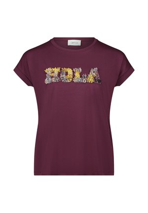 Bordeauxfarbenes T-Shirt mit kurzen Ärmeln, das mit floral inspirierten, strukturierten Applikationen in Gelb, Grau und Weiß das Wort "HOLA" zeigt.
