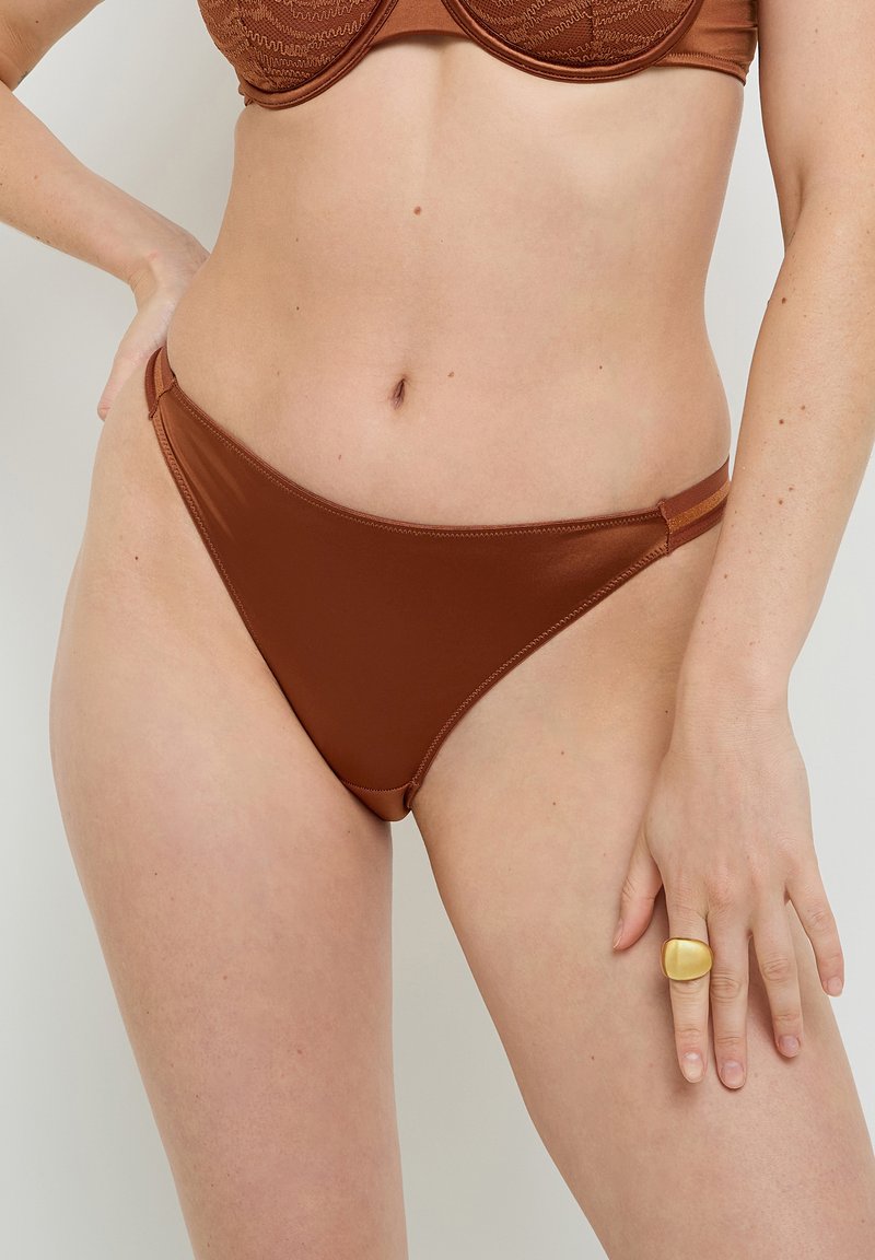 Calzoncini bikini marroni realizzati in tessuto liscio. Presentano un taglio alto con copertura minimale e fasce laterali. Design semplice e senza cuciture.