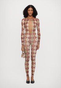 Strikket bodysuit i diamantmønster med jordnære toner av rødt, grønt og beige, med utskjæringer og sirkulære metall detaljer.