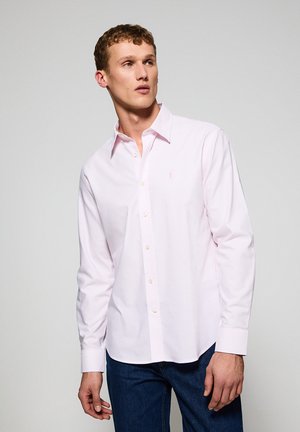 Lichtroze langarm shirt met witte strepen, knoopsluiting aan de voorkant, omgeslagen kraag en klein geborduurd logo op de borst.