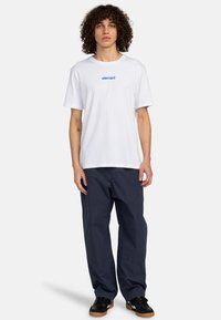 White cotton t-shirt features blue "element" logo on the chest. Paired with navy cargo pants and black sneakers with gum soles.