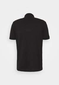 Vue arrière d'un polo noir uni à manches courtes avec un col et des poignets côtelés sur un fond blanc.