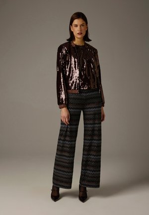 Sequin jacket in dark bronze with a zipper, paired with patterned wide-leg pants in blue, black, and brown zigzag design.