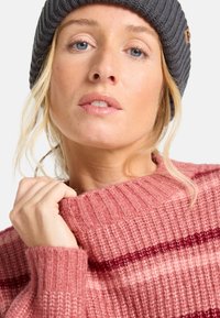 Fleurig gestrickter Pullover in verschiedenen Rosatönen mit gerippter Textur und kastanienbraunen Streifen, ausgestattet mit einem weiten Halsausschnitt und lässiger Passform. Graue Strickmütze inklusive.