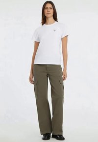 White crew-neck t-shirt with a small logo on the chest, paired with loose-fitting olive green cargo pants featuring multiple pockets.