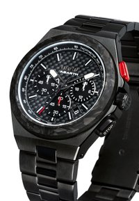 Montre chronographe avec un cadran en fibre de carbone, un boîtier en acier inoxydable noir et un bracelet. Présente des accents rouges et blancs, un tachymètre et des sous-cadrans.