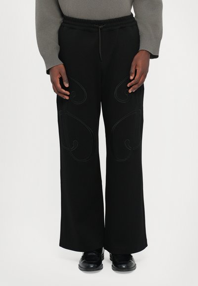 Zwarte broek met wijde benen en een comfortabele elastische tailleband, versierd met ingewikkelde spiraalborduursels aan de voorkant. Gemaakt van een zachte stof.