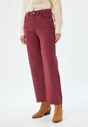 Bredde ben burgunder jeans med høj talje, med knaplukning og frynset kant. Sammen med brune ankelstøvler. Glat stofoverflade.