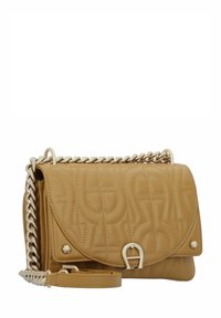 Borsa a tracolla in pelle marrone chiaro trapuntata con una tracolla in catena dorata, chiusura a busta e motivi decorativi in rilievo. Presenta un accent metallico anteriore.