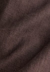 Donkerbruin linnenstof met een gestructureerd oppervlak, met een subtiel geweven patroon en een soepele val. Zacht en licht van uitstraling.