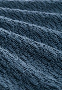 Tessuto navy texture con un motivo a maglia, caratterizzato da punti rialzati intrecciati che creano un effetto rigato, morbido al tatto.
