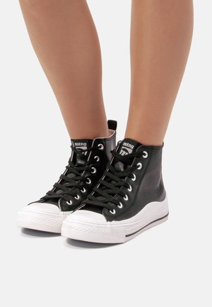 Zapatillas altas negras de piel suave, con suelas de goma blanca, cordones negros y una etiqueta de la marca en la lengüeta.
