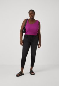 Fuchsia ribbed tank top, black skinny jeans with raw hems, and black slide sandals. Minimalist black handbag, simple hoop earrings.