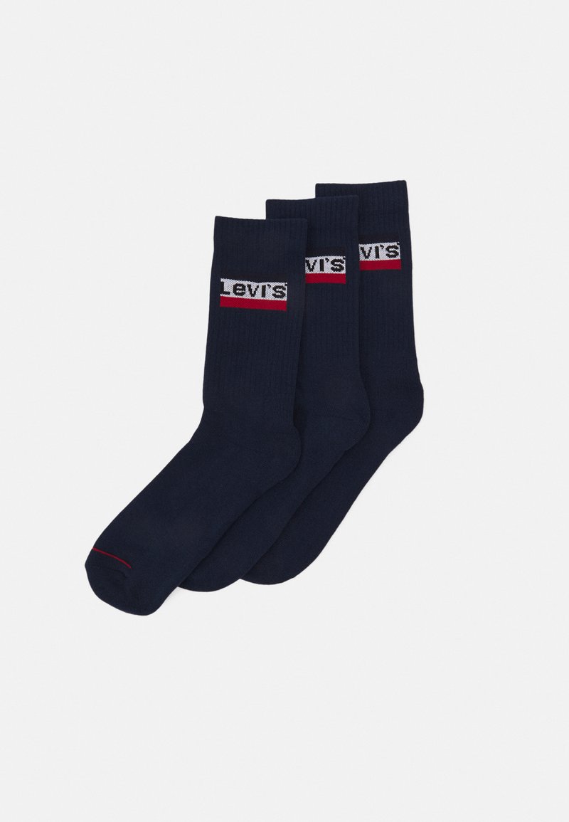 Navy crew socks made of cotton blend, featuring ribbed texture and a logo band in white and red. Pack of three pairs.