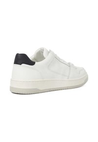 White leather sneaker with a textured surface, light gray rubber sole, and a black accent at the heel. Features flat laces and stitched detailing.