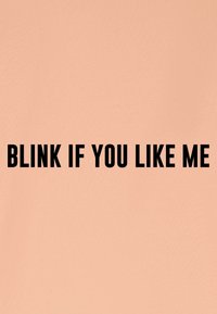 Perzikkleurige achtergrond met vetgedrukte, zwarte tekst die luidt: "KNIPOGEN ALS JE MIJ LEUK VINDT." De tekst is gecentreerd en heeft een gladde, matte afwerking.