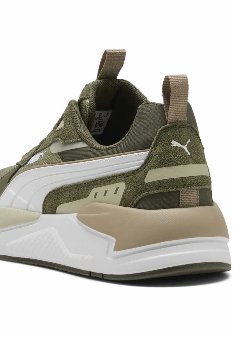 Baskets vertes et beiges avec une tige en tissu lisse, des accents texturés, une semelle épaisse blanche et des éléments de design rayés contrastants.