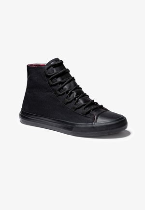 Baskets montantes noires en toile avec des accents en cuir. Elles disposent d'un avant à lacets, d'une semelle en caoutchouc texturée et d'une doublure rouge contrastante.