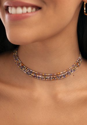 Collar choker de múltiples hebras hecho de pequeñas cuentas coloridas en púrpura, naranja y dorado, con una textura suave y forma circular.