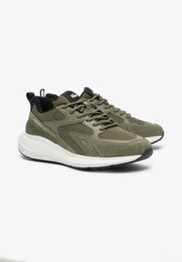 Lacoste sneakers featuring an olive green upper with mesh panels, rubber sole, and white midsole. Includes black laces and logo detail.