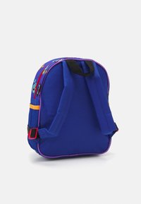 Kék hátizsák lila díszítéssel, hálós oldalamat zsebbel és mesefigurás mintákkal. Állítható pántokkal és piros fém részekkel rendelkezik. Texturált anyag.
