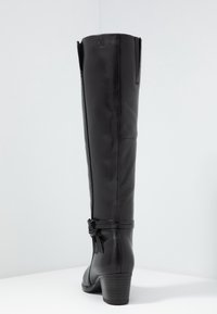 Bota de cuero negra hasta la rodilla con cremallera lateral, acento de lazo en el tobillo y un tacón moderado. Textura suave y diseño aerodinámico.