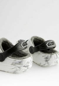 Star-Wars-Motiv-Clogs in Weiß mit einem marmorierten grauen Muster, ausgestattet mit einem schwarzen verstellbaren Riemen und einem weichen grauen Fleece-Futter.