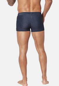 Navy swim trunks with a grid pattern, featuring a solid waistband. Made of smooth fabric, designed for a fitted shape, suitable for swimming.